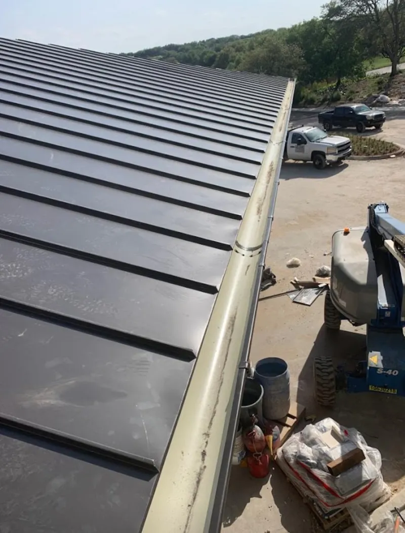 Standing seam panel and gutter detail on a metal roofing jobsite in Suffern